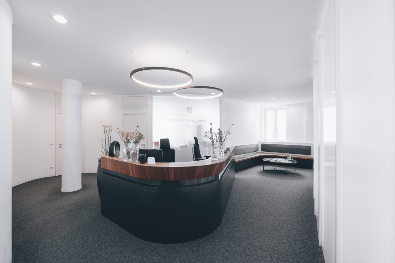 Innenansicht des Notarbüros mit leerem Empfangstresen und Wartebereich im Hintergrund rechts.